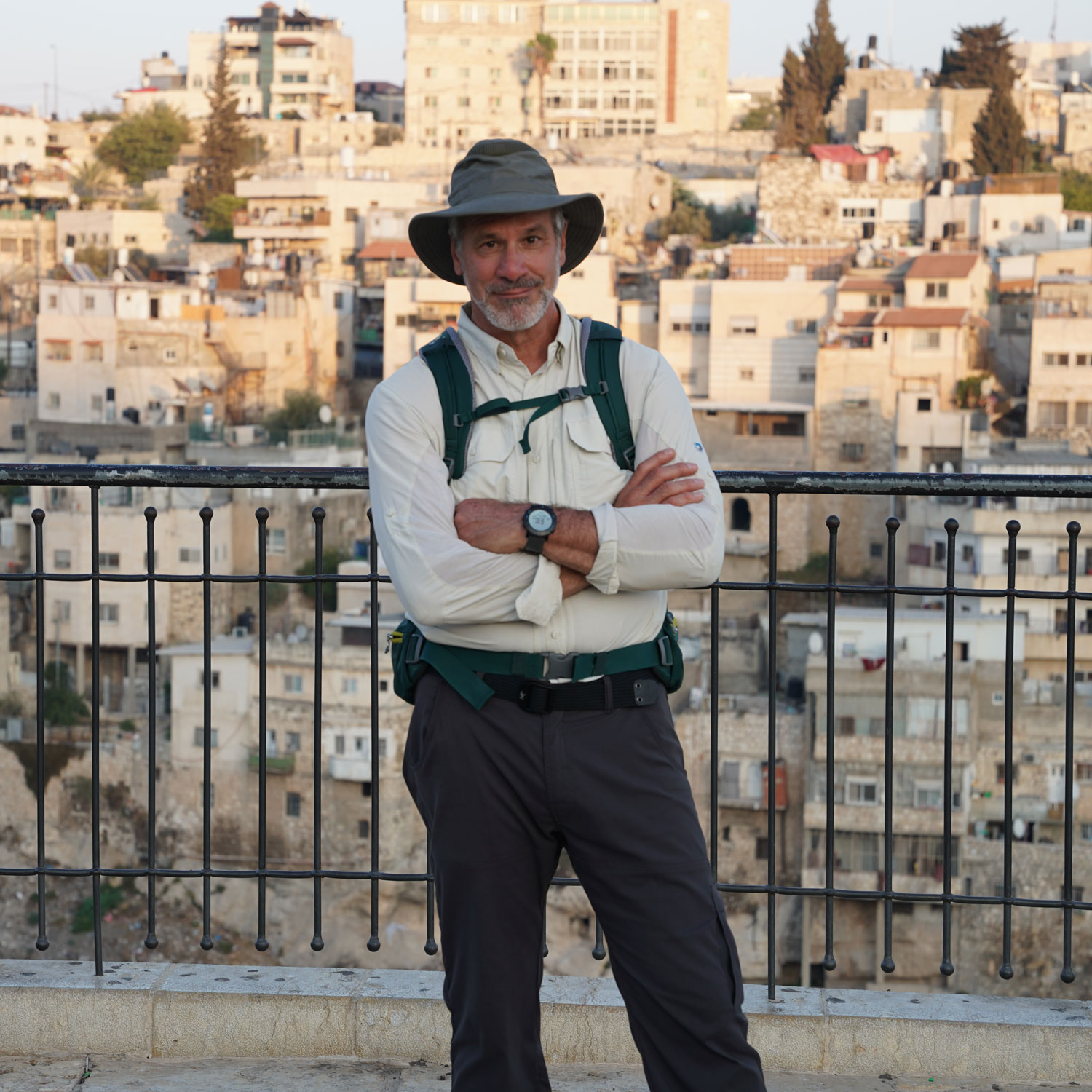 Man with hat and backpack in urban setting