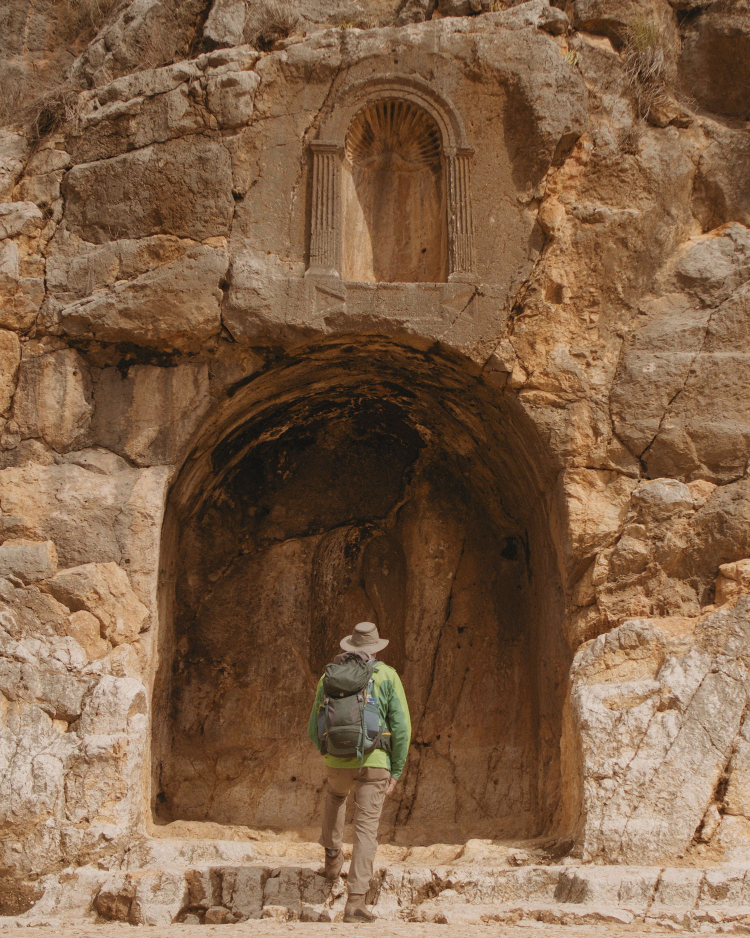 Hiker explores ancient rock carving site.